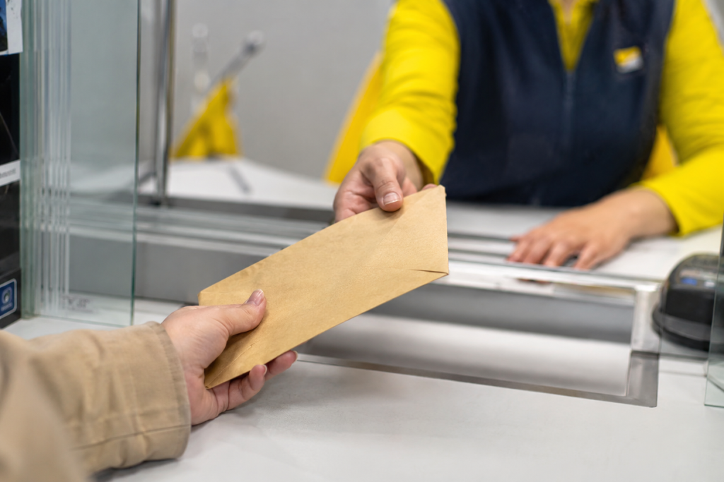 Personne récupérant une lettre recommandée en Espagne dans une boîte aux lettres