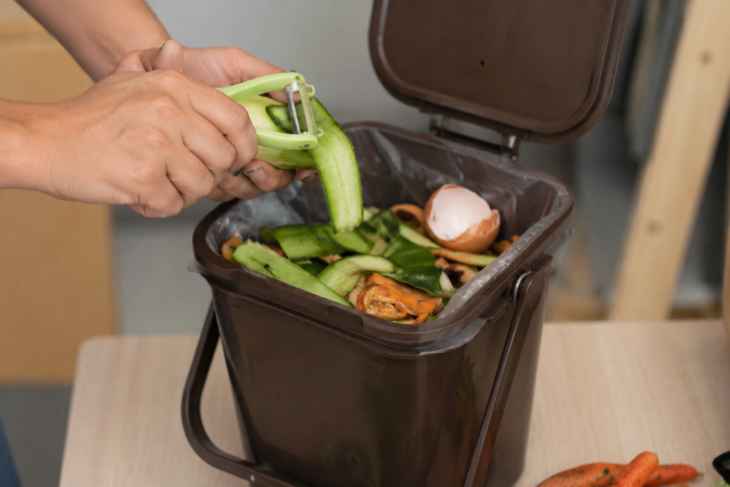 Recycler en Espagne : le guide complet pour comprendre les règles et les différences avec la France 3 Recycler en Espagne : une personne jette des épluchures de légumes dans une poubelle à compost.
