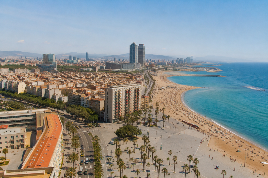 Des personnes profitent de la plage de Barcelone au coucher du soleil, un environnement idéal pour apprendre l'espagnol à Barcelone en échangeant avec les habitants.