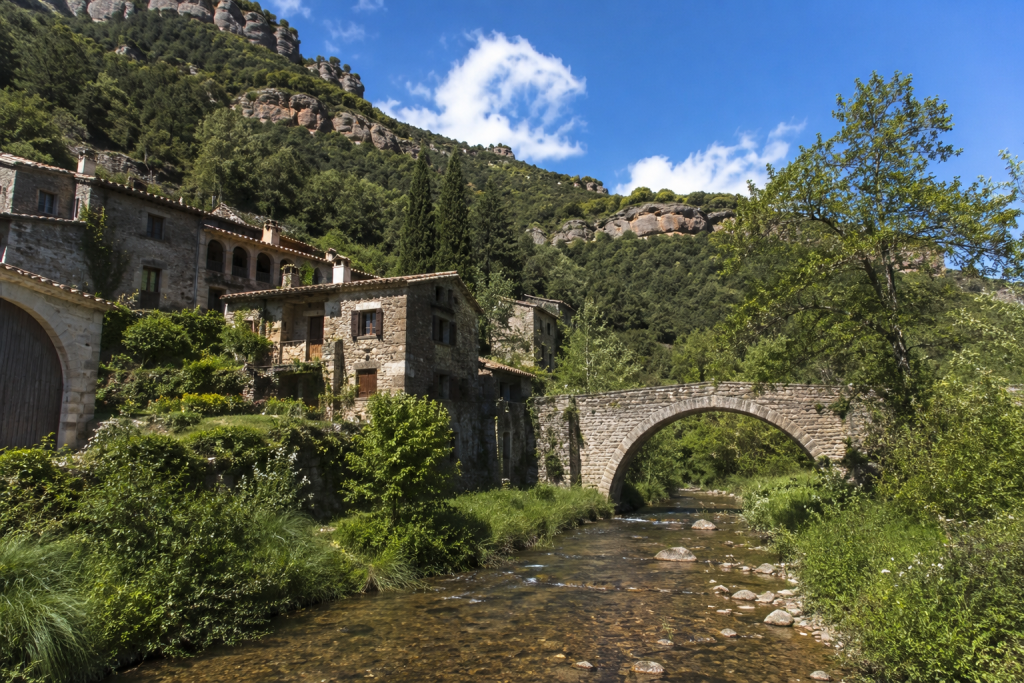 Hors des sentiers battus : les meilleures randonnées autour de Barcelone 8 Randonnées autour de Barcelone dans le Montseny avec un village en pierre et un pont médiéval sur la rivière.